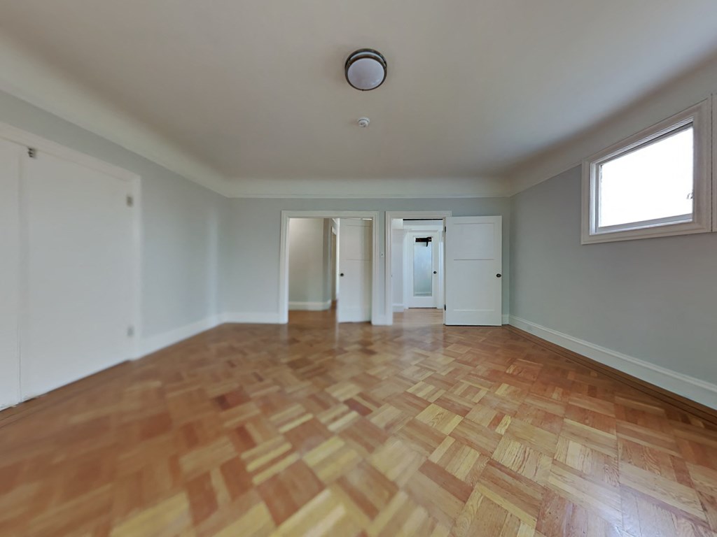 an empty living room with a hard wood floor