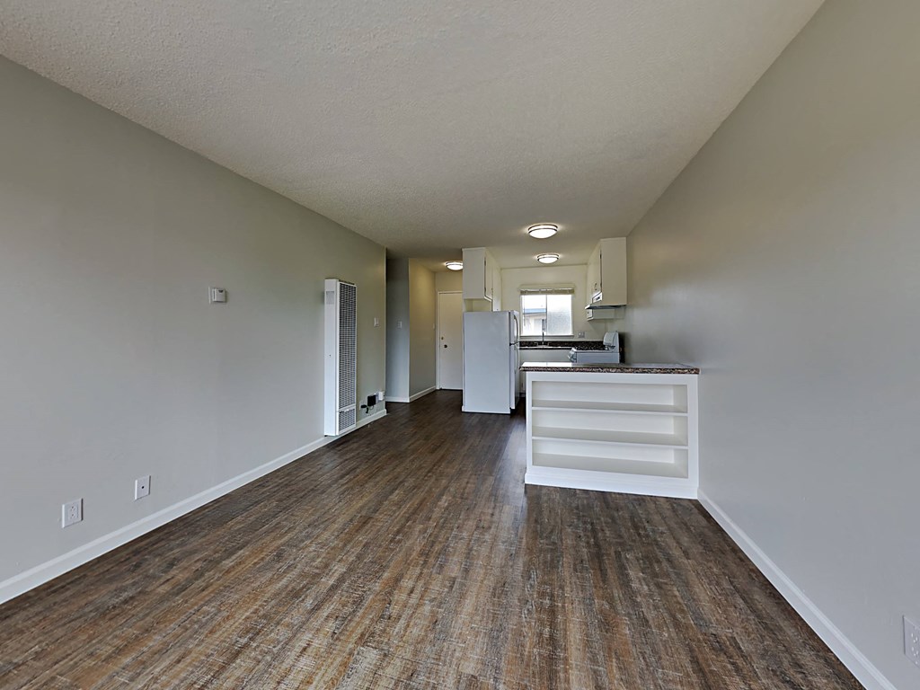 a living room and kitchen with a wood floor