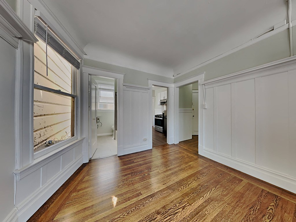 a living room with white walls and wood floors