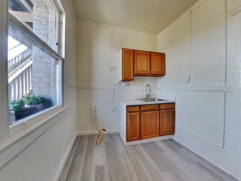 an empty kitchen with wooden cabinets and a window