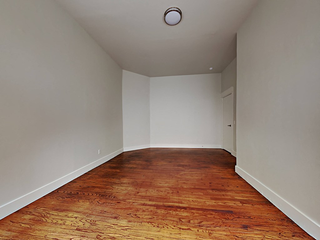 a empty room with wood floors and white walls