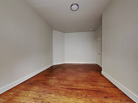 a empty room with wood floors and white walls