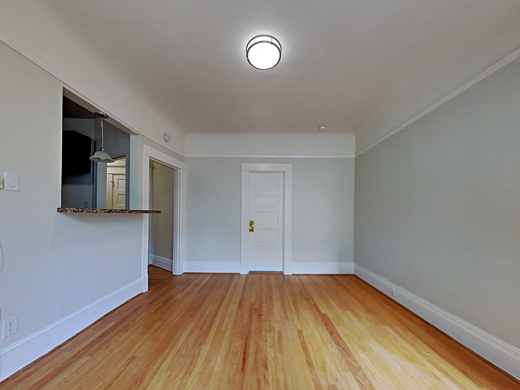 a living room with wood floors and a white door