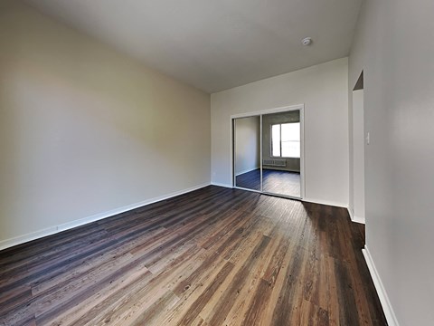 an empty living room with wood flooring and white walls