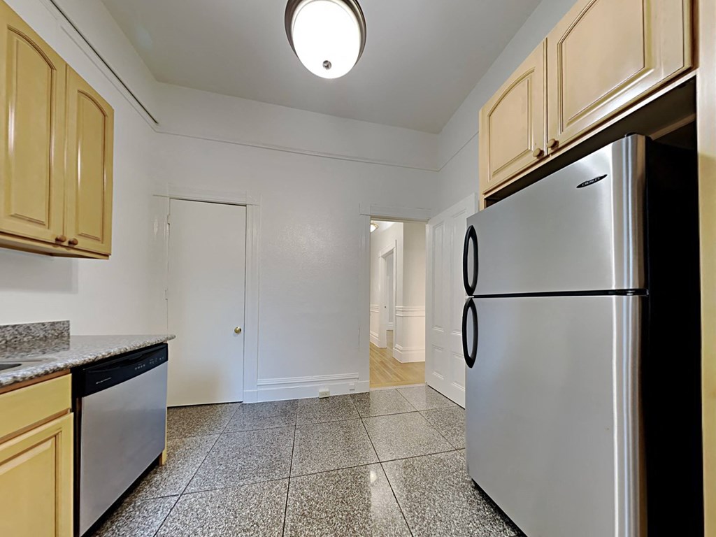 a kitchen with stainless steel appliances and white walls
