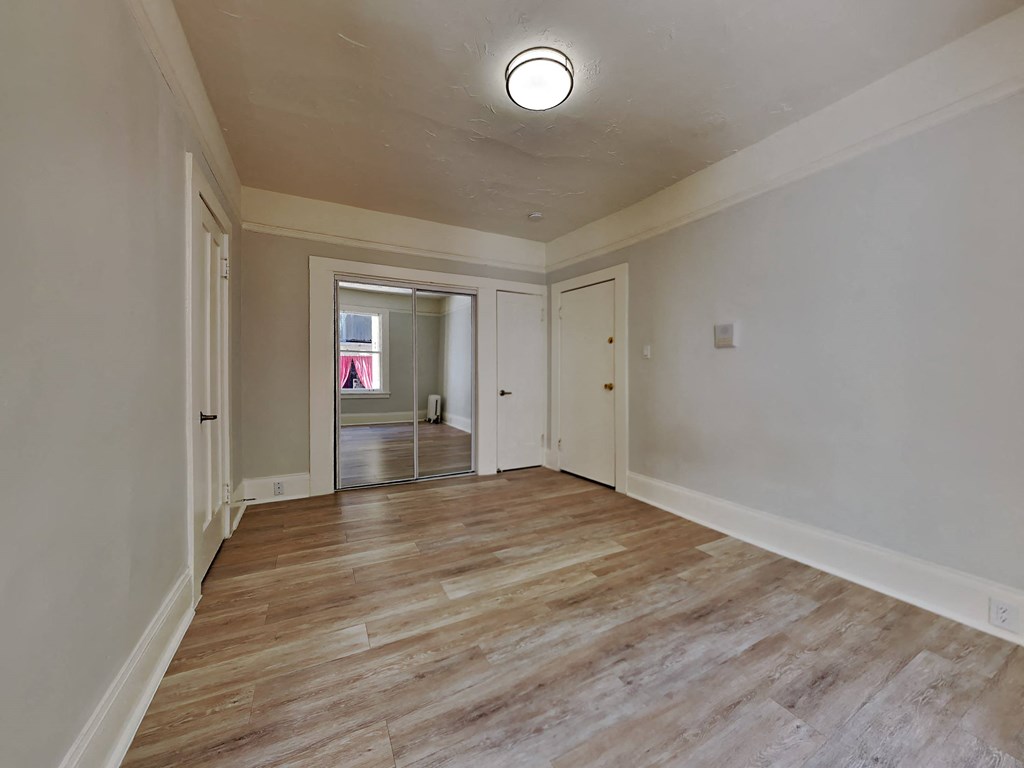 a living room with white walls and a wooden floor