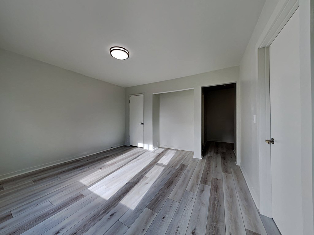 a renovated living room with wood floors and white walls