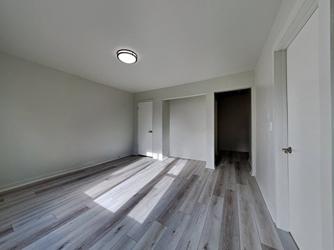 a renovated living room with wood floors and white walls