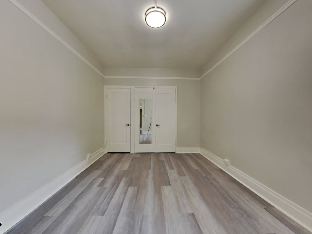an empty living room with white walls and wood flooring