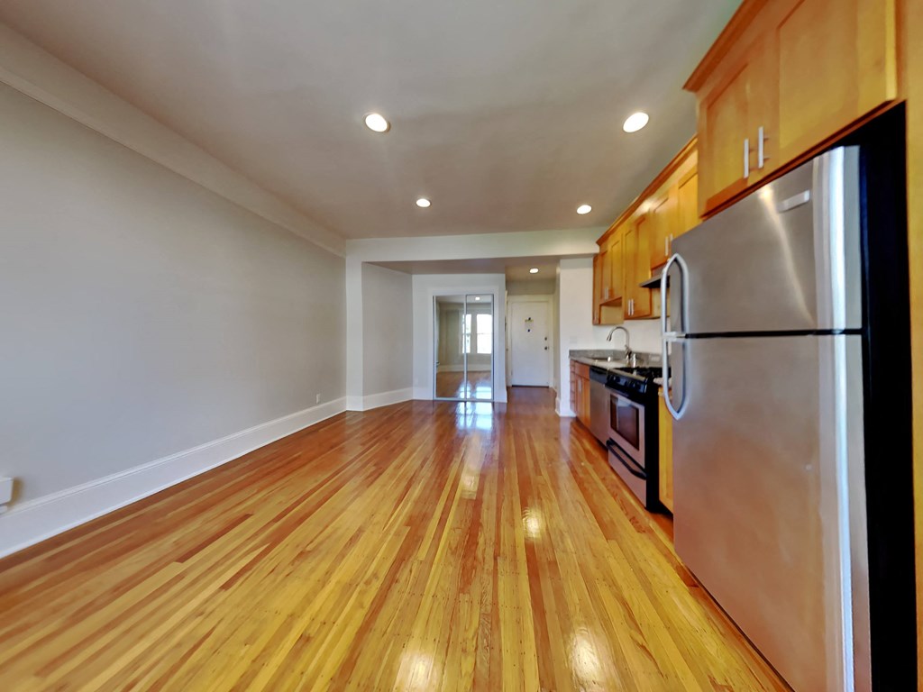 a renovated kitchen with stainless steel appliances and wooden floors