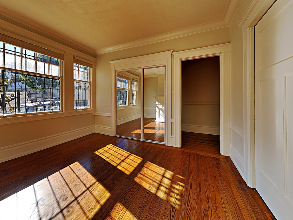 an empty living room with sunlight coming through a window