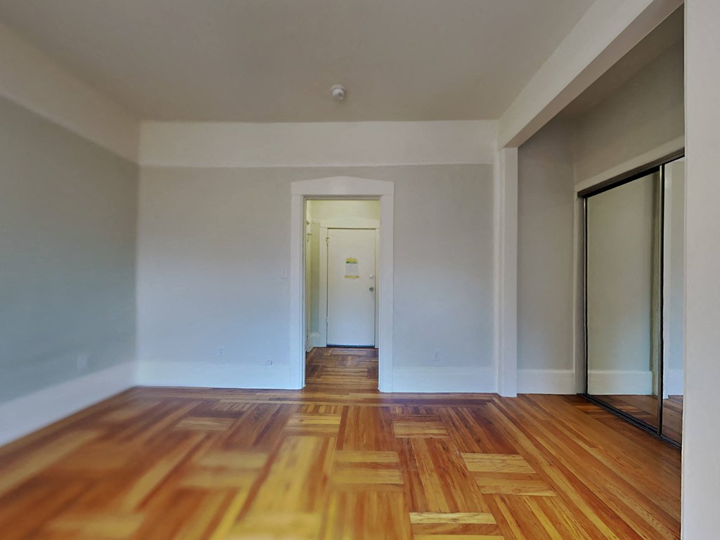 a living room with a wooden floor and white walls