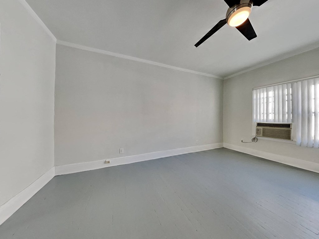 an empty living room with white walls and a ceiling fan
