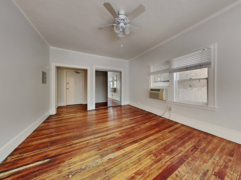 a living room with wood floors and a ceiling fan