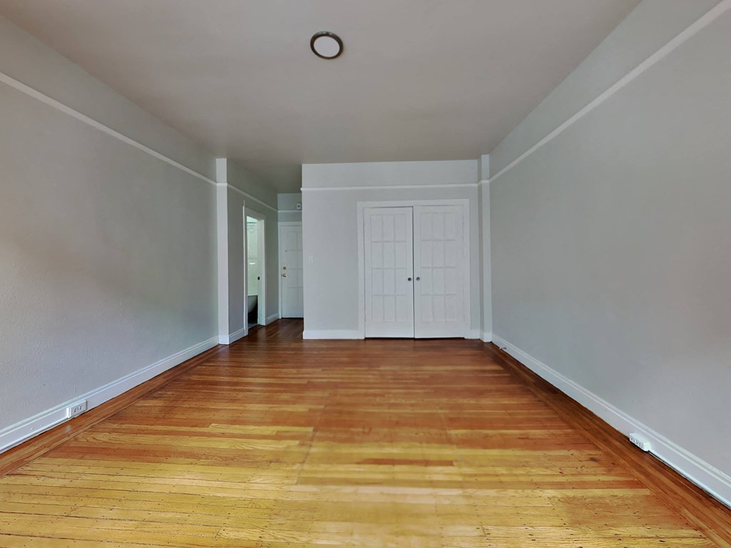 a empty room with wood floors and a white door