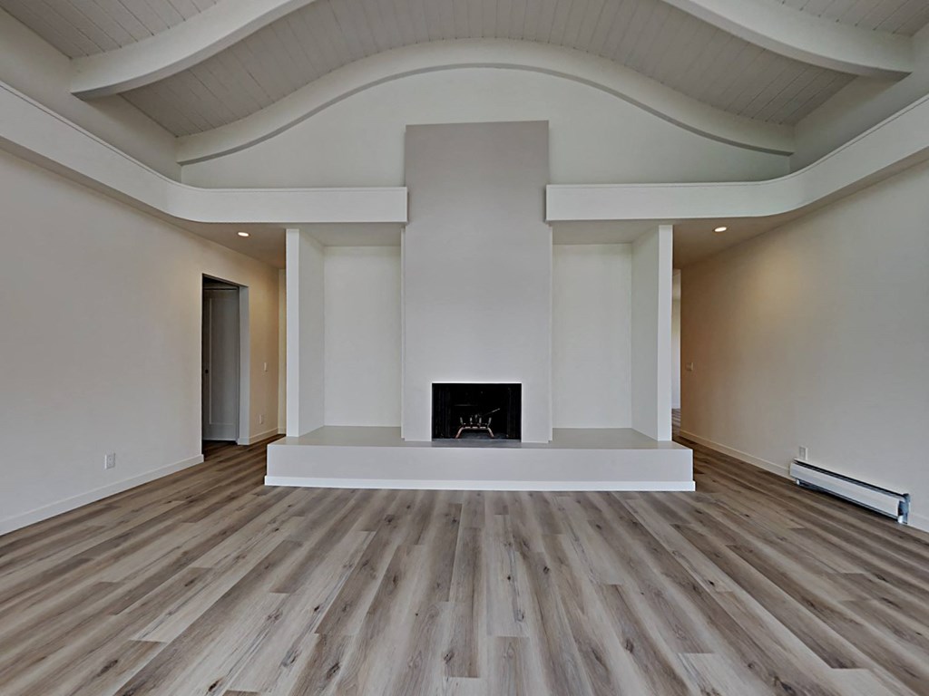 a living room with a fireplace and wooden floors