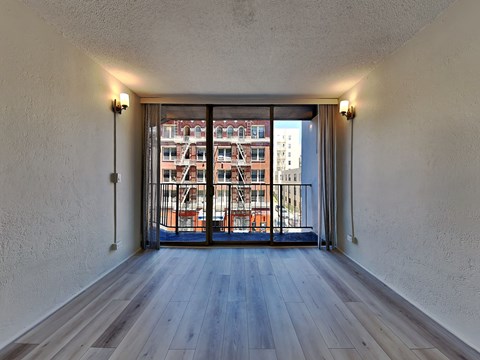 spacious living room with balcony overlooking the city