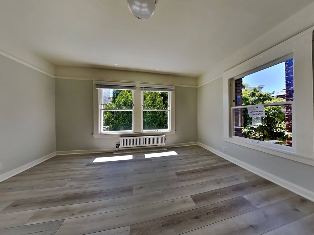 a living room with wooden floors and a large window
