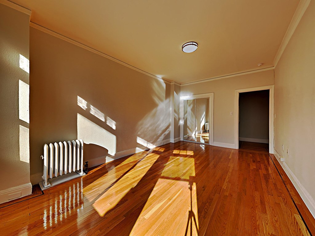 an empty living room with a hard wood floor