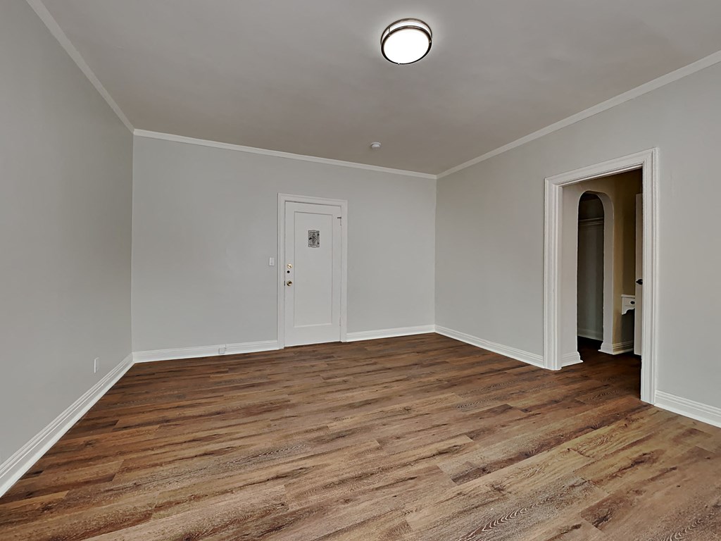 a empty living room with wood floors and a white door