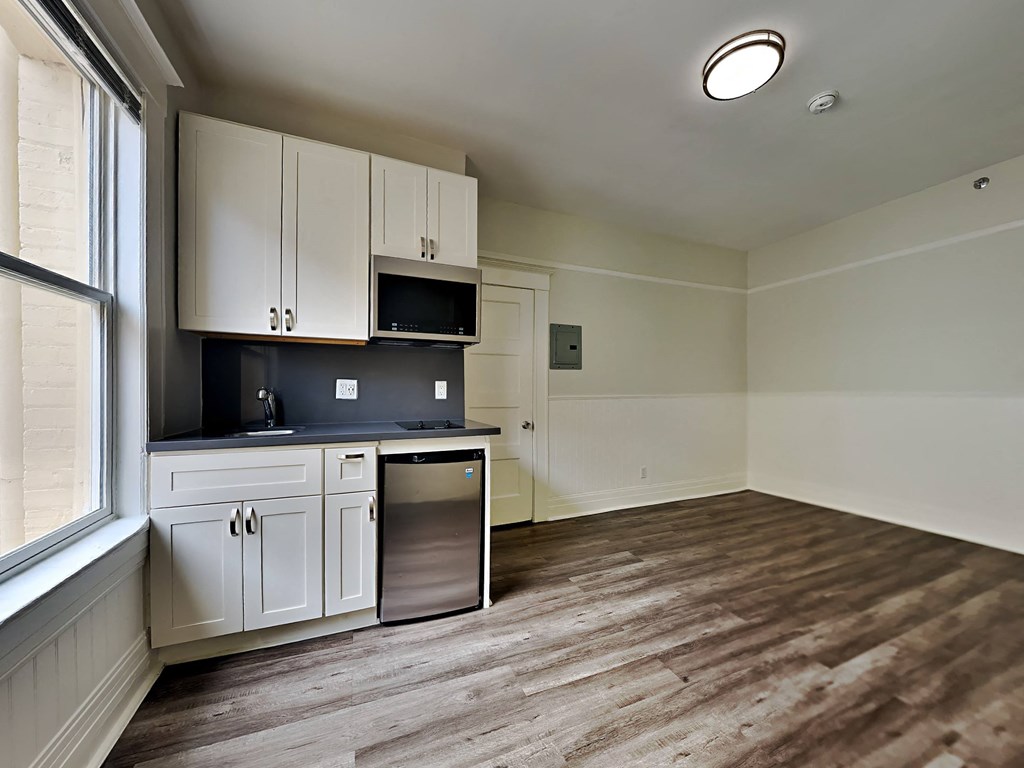 a kitchen with white cabinets and a dishwasher and a window