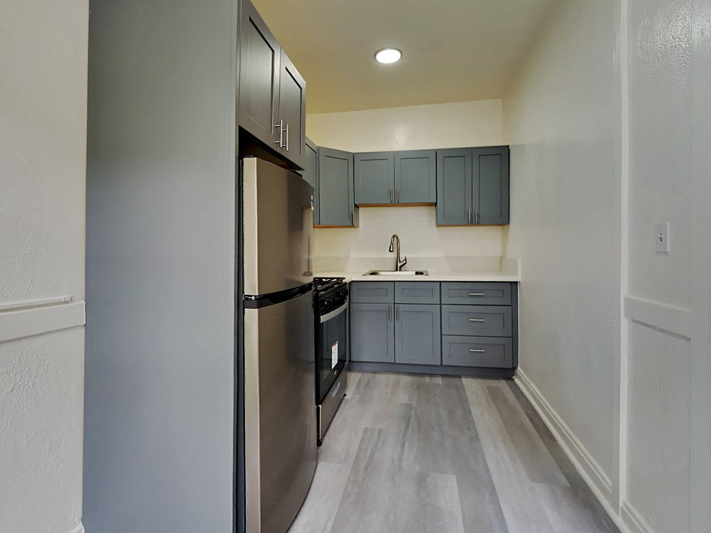 an empty kitchen with stainless steel appliances and blue cabinets