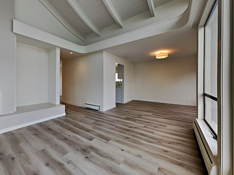 a living room with wood flooring and a large window