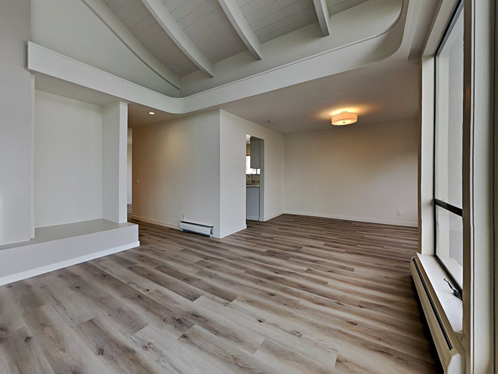a living room with wood flooring and a large window
