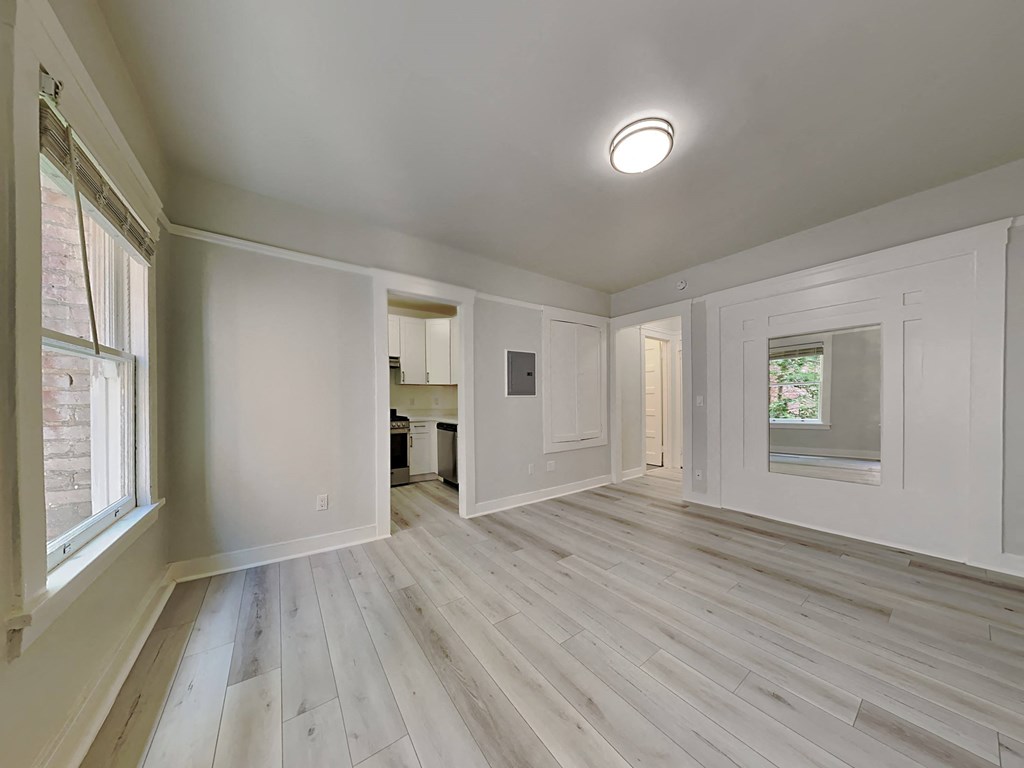 a renovated living room with white walls and wood floors