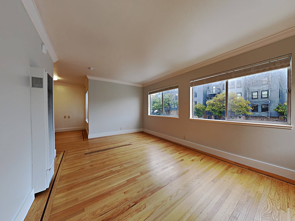 a living room with a large window and wooden floors