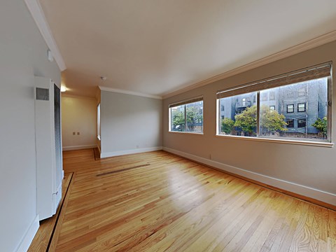 a living room with a large window and wooden floors