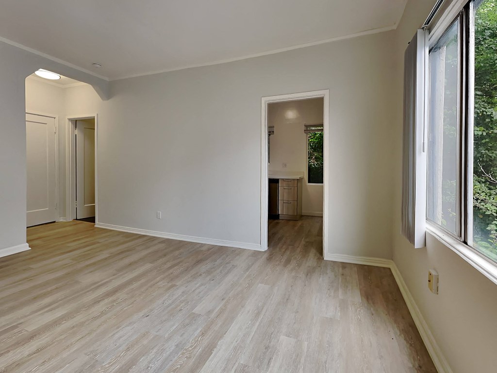 a living room with wood floors and a large window
