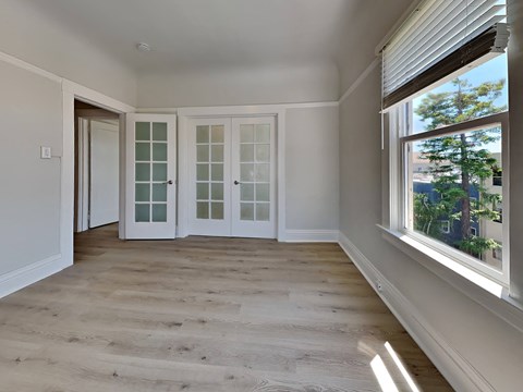 a living room with white doors and a window