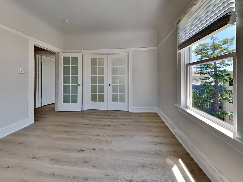 a living room with white doors and a window