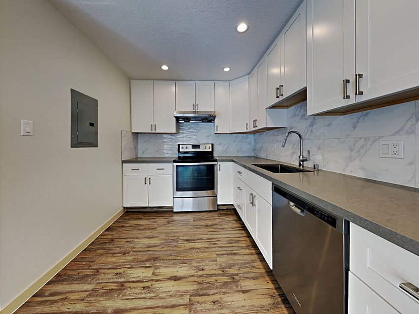 a kitchen with white cabinets and stainless steel appliances