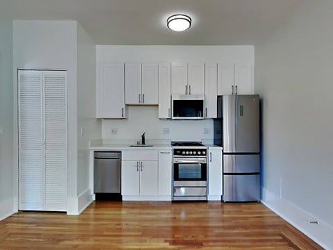 a kitchen with white cabinets and stainless steel appliances