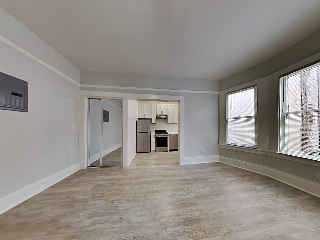 a living room with a large window and a door to a kitchen