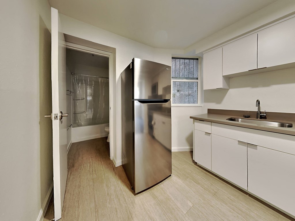 a kitchen with white cabinets and a stainless steel refrigerator