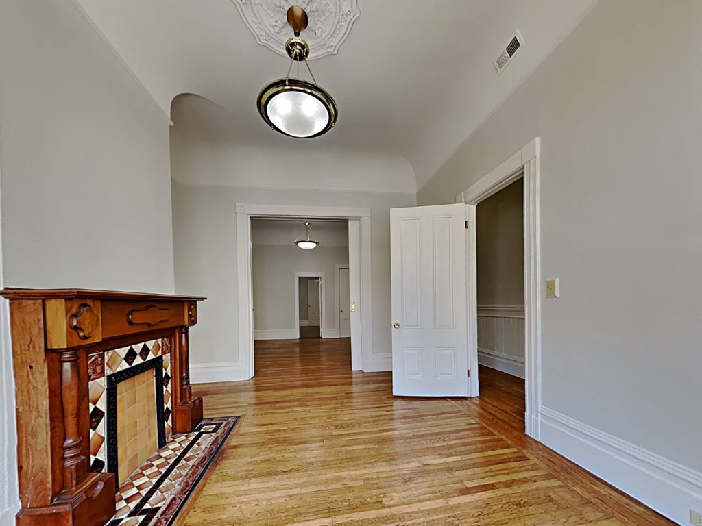 a living room with a fireplace and a door to a hallway