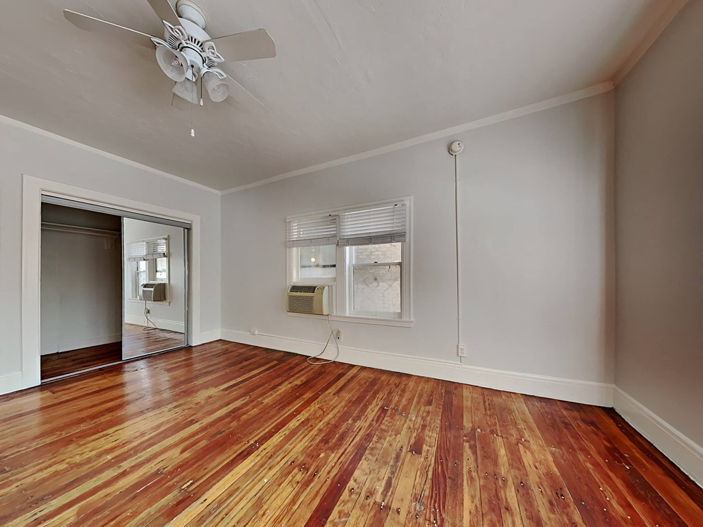 a living room with wood floors and a ceiling fan