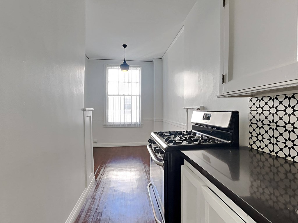 an empty kitchen with a stove and a window