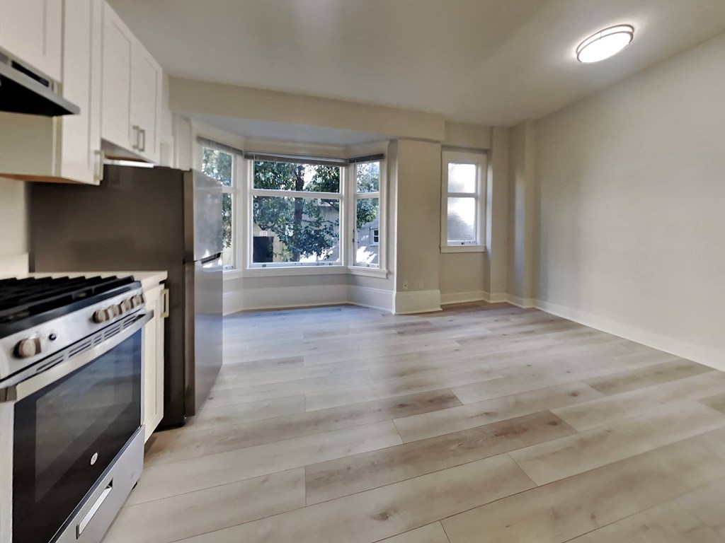 an empty kitchen with a stove and a window
