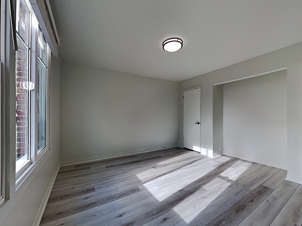 an empty room with wood flooring and a window