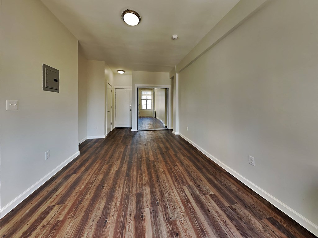 a long hallway with wood floors and white walls
