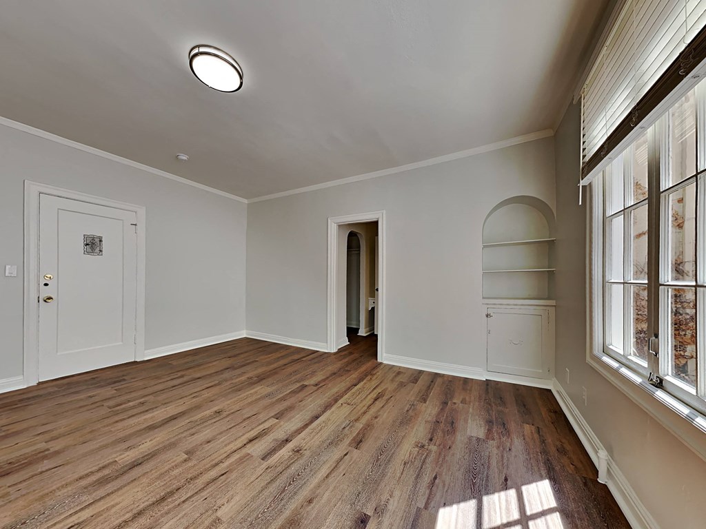 a living room with white walls and wood floors