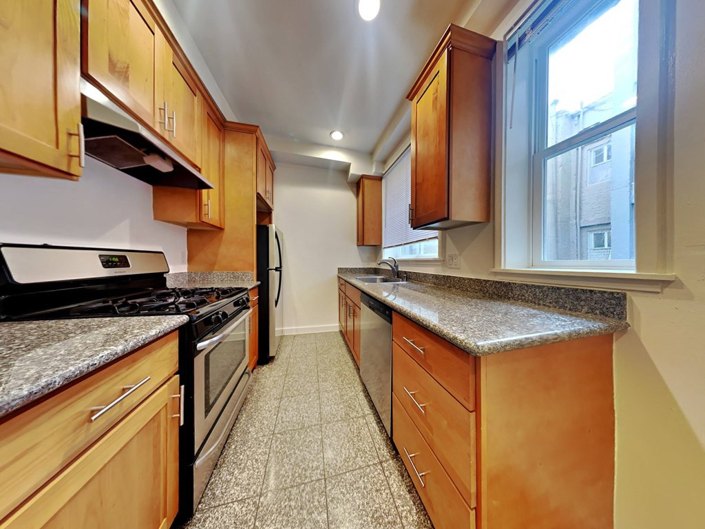 a kitchen with granite counter tops and wooden cabinets
