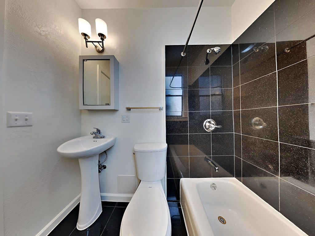 a bathroom with a tub sink and toilet and a shower