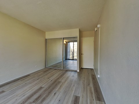 an empty living room with wood floors and a sliding glass door