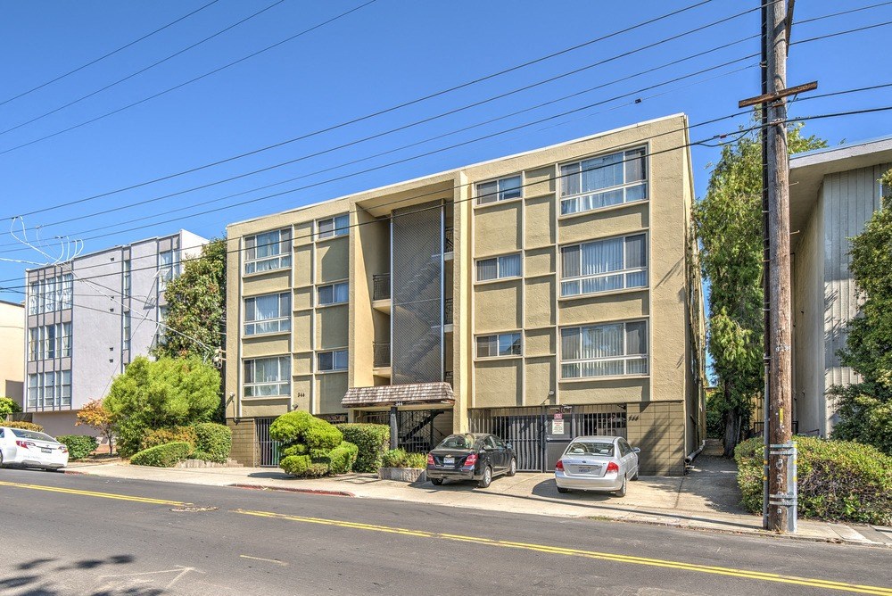 an apartment building with cars parked in front of it