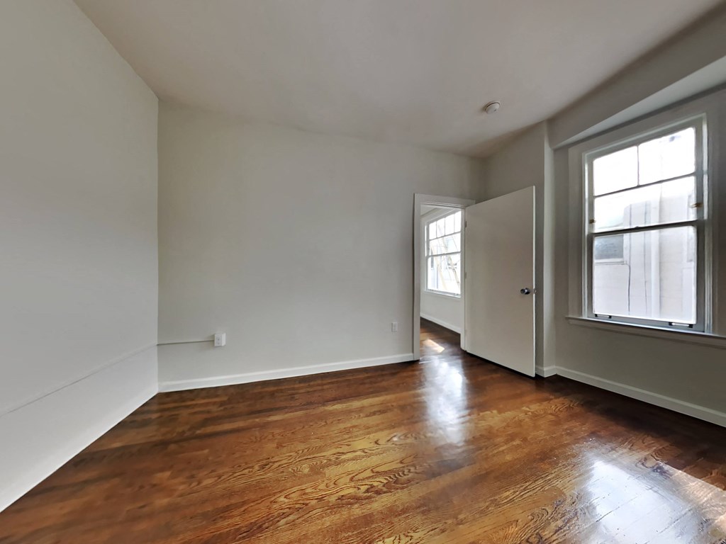 a living room with white walls and wood floors
